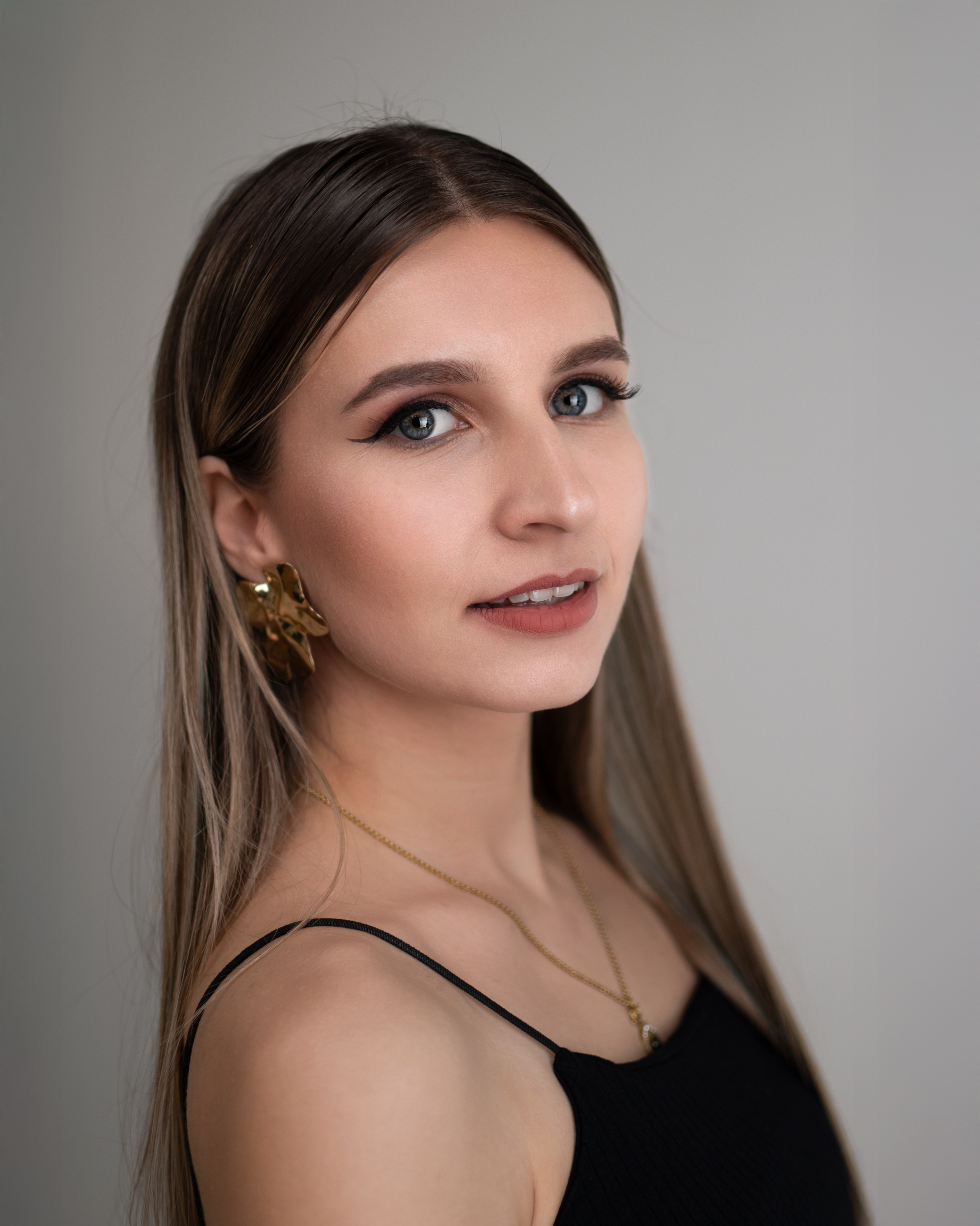 Portret Sylwii na szarym tle — fotografia wizerunkowa Michała Żaby